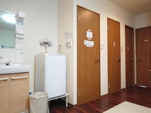 a room with a refrigerator and two wooden doors at Guesthouse Kyoto Abiya in Kyoto