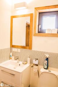 a bathroom with a sink and a toilet and a mirror at BioDomek, naturalny dom z przepięknymi widokami na góry in Gniewoszów