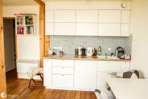 a kitchen with white cabinets and a counter top at BioDomek, naturalny dom z przepięknymi widokami na góry in Gniewoszów