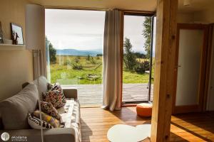 sala de estar con sofá y puerta de cristal grande en BioDomek, naturalny dom z przepięknymi widokami na góry, en Gniewoszów