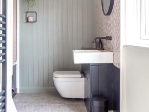 a bathroom with a white sink and a toilet at Stag Cottage in Penrith +23 photos