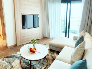 sala de estar con sofá blanco y mesa en HB Serviced Apartment - Alacarte Hạ Long, en Ha Long