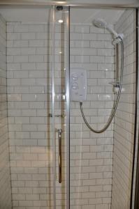 a shower with a glass door in a bathroom at The Hollybush Inn and B&B in Priors Marston