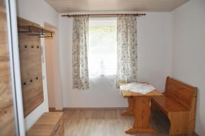 Zimmer mit einem Holztisch und einem Fenster in der Unterkunft Mostheuriger Steyrdurchbruchalm in Leonstein