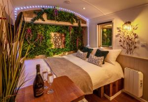 a bedroom with a bed with a bunch of plants at Hillside View Shepherds Hut - Ockeridge Rural Retreats in Little Witley