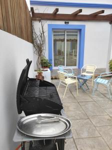 a grill on a patio with chairs and tables at Apartamentos Atenea Jerte in Jerte