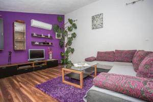 una sala de estar con paredes moradas y un sofá púrpura. en Apartman PANTAN en Trogir