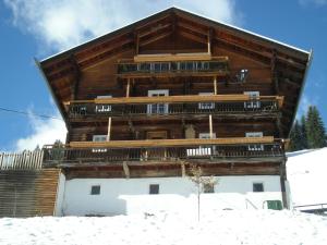a large wooden building in the snow at Haus Guglprasta in Sankt Veit in Defereggen