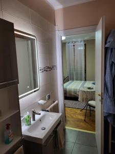 a bathroom with a sink and a mirror and a bedroom at B&B RUFHOUSE in Lovere