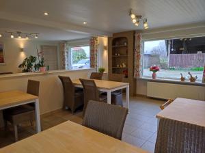 un restaurant avec des tables et des chaises en bois et une fenêtre dans l'établissement B&B Het Polderhof, à Jabbeke