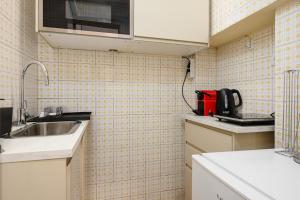 a small kitchen with a sink and a microwave at Brera - San Marco Cozy Apartment in Milan