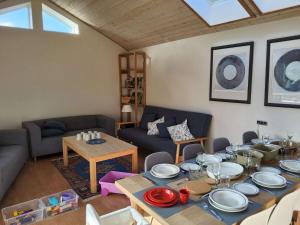 una sala de estar con una mesa con platos. en Family Friendly Apartment, Garden, 900m LegoHouse, Lalandia, Legoland en Billund