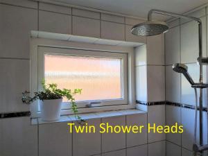 a window in a bathroom with a plant on a shelf at Family Friendly Apt A, Garden, 900m LegoHouse, Lalandia, Legoland in Billund +42 photos