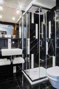 a bathroom with a shower and a sink and a toilet at INX Design Hotel in Kraków