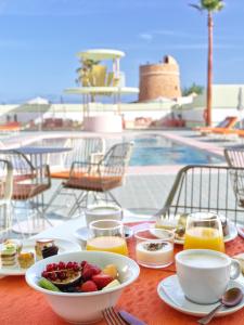 un tavolo con un cesto di frutta e un cesto di succo di Grand Paradiso Ibiza - Adults Only a Baia di Sant'Antoni