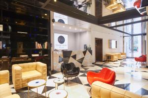 a lobby with chairs and tables in a building at INX Design Hotel in Kraków