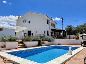 a villa with a swimming pool in front of a house at Todos Y Tonya in Archidona