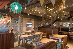 a restaurant with wooden tables and chairs and a staircase at TSCaravan, Haven, Golden Sands in Mablethorpe