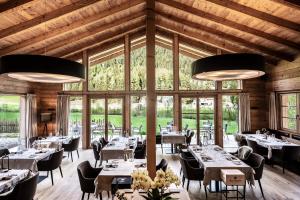 comedor con mesas y sillas y ventanas grandes en Chalets Valsegg, en Valles