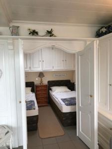 a bedroom with two beds and white cabinets at Berliner Ring - Whg 26 in Wyk auf Föhr