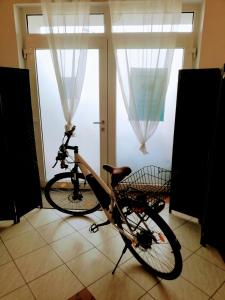 ein Fahrrad in einem Zimmer mit Fenster geparkt in der Unterkunft LANDHAUS KLAMBAUER Ferienapartments Thermennähe St Martins Therme in Frauenkirchen