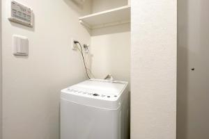 een badkamer met een wasmachine en een wastafel bij TASUKI smart Higashinakano in Tokyo