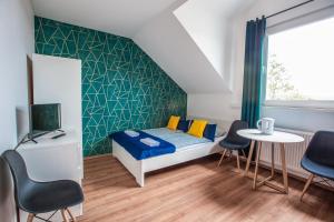 a bedroom with a bed and a table and chairs at WillaMaks in Ustka