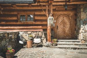 une maison avec une porte en bois et une terrasse en pierre dans l'établissement Pokoje Javorina, à Zakopane