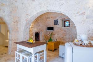 eine Küche mit einer Steinmauer und einem Tisch in einem Zimmer in der Unterkunft Dimora Rutica in Selva di Fasano