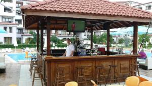 a man standing at a bar with a television at Harmony Hills Poseidon in Rogachevo