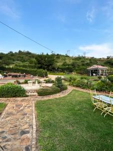 un jardín con mesa y sillas en la hierba en Jobe Guesthouse, en Pietermaritzburg