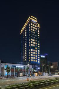un palazzo alto con luci accese di notte di Hotel tt Gupo a Busan