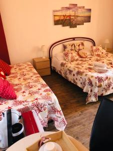 a bedroom with two beds and a table with a table at B&B Antonella in Taormina