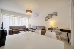 a living room with a table and a couch at IMMOGROOM - Renovated apartment - Terrace - AC in Cannes