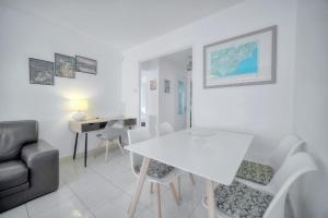 a living room with a white table and chairs at IMMOGROOM - Renovated apartment - Terrace - AC in Cannes