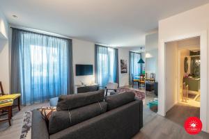 ein Wohnzimmer mit einem Sofa und ein Wohnzimmer mit blauen Vorhängen in der Unterkunft Wild Zagara Luxury Sea View in La Spezia