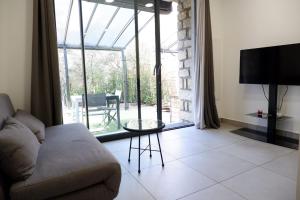 a living room with a couch and a large window at N7 Maison T2 climatisé avec jacuzzi privé in Ajaccio