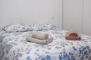 a bed with towels and pillows on it at N7 Maison T2 climatisé avec jacuzzi privé in Ajaccio