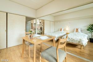 a room with two beds and a table and chairs at Nanei Building - Vacation STAY 04909v in Kagoshima