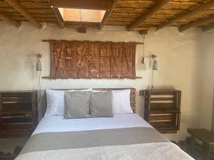 a bedroom with a bed with a wooden headboard at El Huarango Eco retreat in La Huaica
