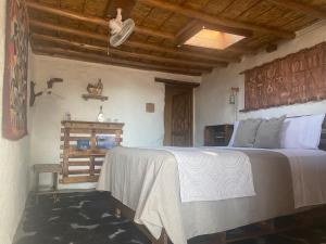 a bedroom with a large bed with a wooden headboard at El Huarango Eco retreat in La Huaica