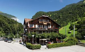 a large wooden building in the middle of a mountain at Hotel Steinbock in Lauterbrunnen