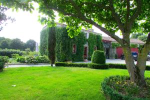 a house covered in green ivy next to a yard at Maison charmante à Landevieille avec jardin clos in Landevieille +6 photos