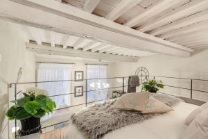een slaapkamer met een groot bed en een wit plafond bij Paolo Guinigi, Elegant Apartment Suite, Masterful Interior inside the Walls of Lucca in Lucca