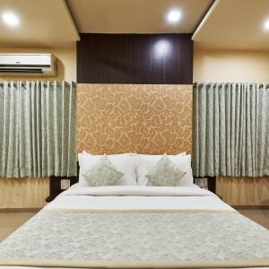 a bedroom with a large bed and curtains at Hotel Atria, Kolhapur- Opposite To Central Bus Station in Kolhapur