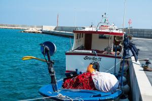 a small boat tied to a dock in the water at Monte sul mare in Savelletri di Fasano