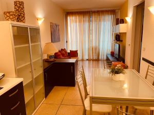 cocina y sala de estar con mesa y sofá en CONDOMINIO SATURNO, en Lido di Jesolo