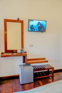 un espejo en la pared junto a una mesa y un cajón en Even Beach Resort en Wayikkal