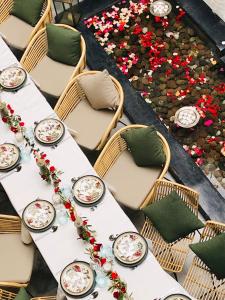 einen Tisch mit Stühlen, Teller und Blumen darauf in der Unterkunft Riad Villa Wengé & Spa in Marrakesch