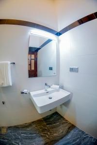 y baño con lavabo y espejo. en Even Beach Resort en Wayikkal